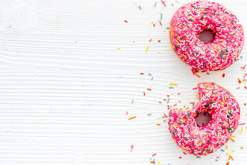 Pink berry donuts flat lay, top view. Glazed and sprinkles doughnuts