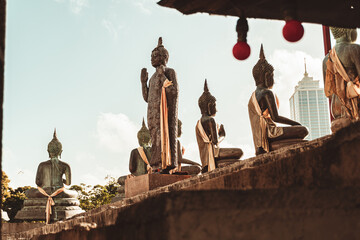 Posągi Buddy, statuy w miejskiej scenerii na tle nieba. © insomniafoto
