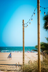 Line of light bulbs lighting the way to a terrace on the beach
