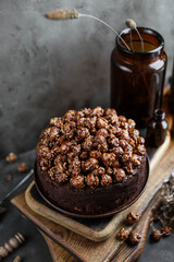 Chocolate cake decorated with popcorn. Photo in dark shades.