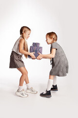two girls are fighting for boxes with gifts. Each is trying to pull gifts in its own direction.