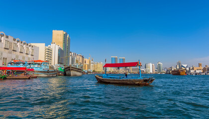 Obraz premium An Abra, water taxi in the middle of the Dubai Creek in the UAE in springtime