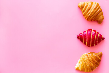 Set of croissants - berry, classic - on pink background top view