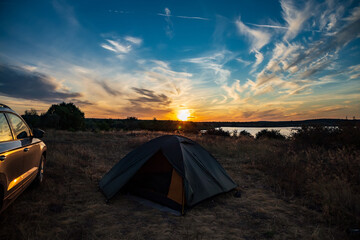 Fototapeta na wymiar Beautiful sunset over tourist tent and car in summer.