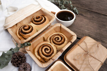 Obraz na płótnie Canvas Cinnamon rolls on a plate from nature and black coffee on a wooden table.