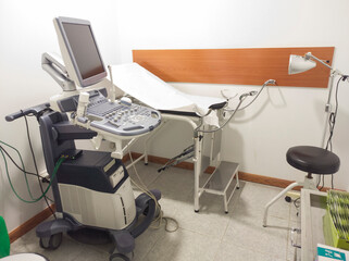 gynecology room with ultrasound machine and stretcher.