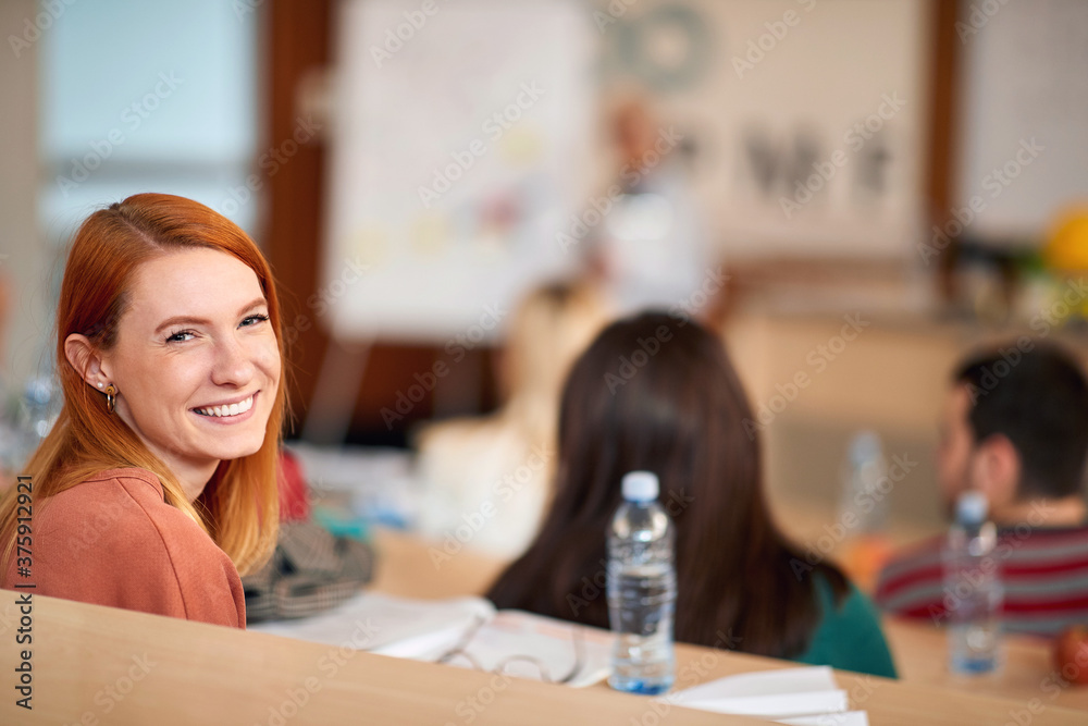 Wall mural Young smiling girl sitting in amphitheater