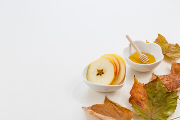 Rosh Hashana, Jewish New Year, symbols of the holiday, apple, honey, pomegranate, candelabrum, Shofar ram's horn, on white background. Selective focus.