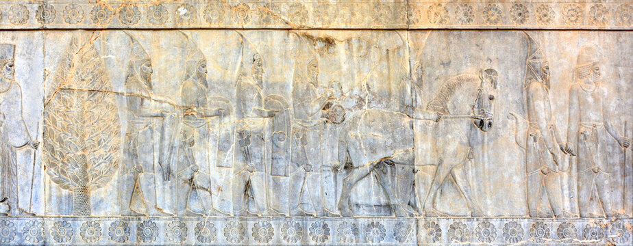 Bas-relief on the southern wall of the east stairway of the Apadana in Persepolis:Scythian tribute bearers, armed and wearing distinctive headgear, offering a bracelet and folded coats and trousers .