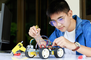Young asian teen enjoy with toy car workshop.
