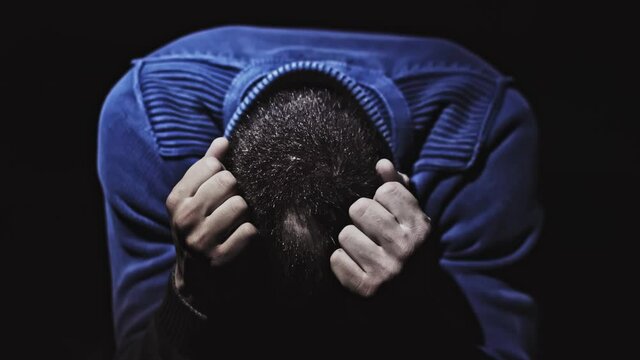 Balding caucasian man grabs head in angst over hair loss Close up shot