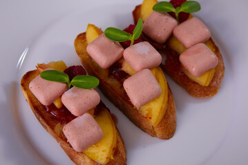 The Appetizer. Foie Gras with mango and raspberry on bread. Shallow dof.