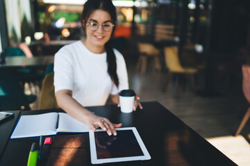 Young female with notebook and tablet in cafe