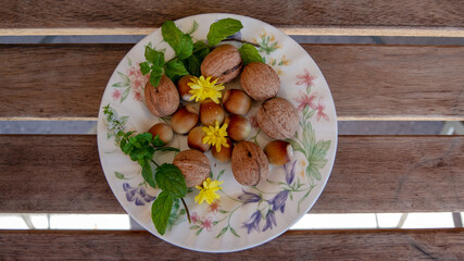 Arrangement of hazelnuts, walnuts, mint and yellow flowers