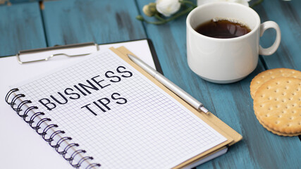 Business reports, blank paper sheet, glasses and charts - directly above view of office table workspace with FINANCIAL TIPS text.