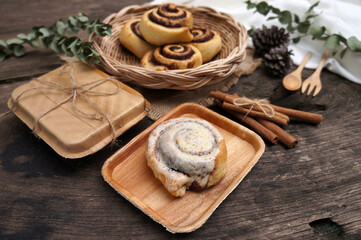 Homemade Cinnamon rolls on a plate from nature on a wooden table.