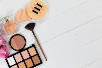 Make up view with pink flowers and perfume on white background