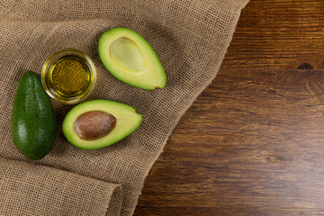 View of two avocados and olive oil bottle on wood table background