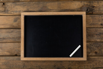 View of a black board with a chalk on wood table background