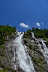 waterfall in the mountains with trees and blue sky no people copy space