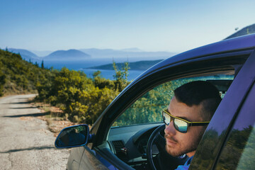 Portrait of a man in a car on the road. Travel concept.