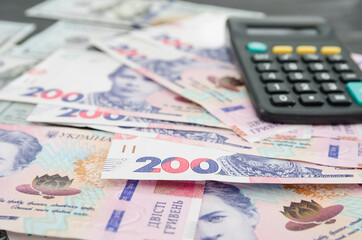 Obraz na płótnie Canvas Ukrainian hryvnia and calculator. Banknotes of 200 hryvnia. Financial concept. Much money.
