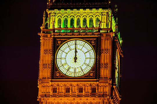 Big Ben of the Houses of Parliament London England UK at night striking midnight on New Years Eve which is a popular travel destination tourist attraction landmark of the city centre stock photo image
