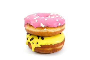 two sweet donuts in pink and yellow glaze and with chocolate sprinkles isolated on a white background. Side view.