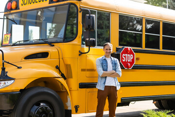 Smiling bus driver looking at camera outside the elementary school