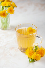 Cup of healthy flowers dandelion tea. Herbal medicine. Light background