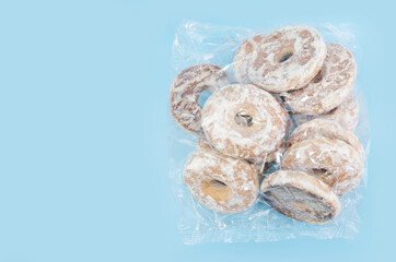 gingerbread cookies in white glaze in a plastic bag on a blue background. Copy of space.
