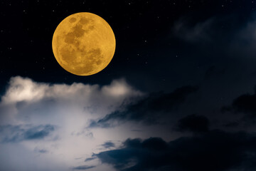 Fototapeta na wymiar Full moon over clouds on the sky.