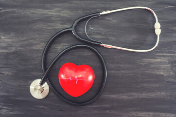 red heart and stethoscope on a black background. Health concept.