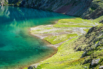 Lac limpide couleur émeraude à la montagne devant des bras de ruisseaux 