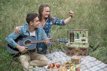 Naklejka na ściany i meble happy young couple sitting on a picnic