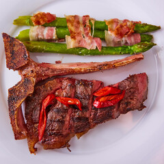 Cooked t-bone meat with asparagus vegetable. Shallow depth of field.