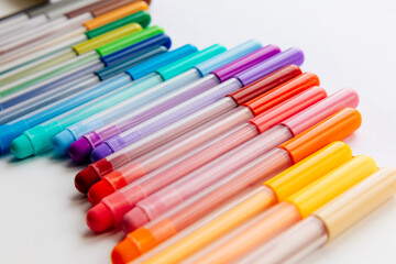 multi-colored markers on a white background