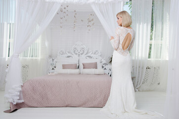 Fototapeta na wymiar girl in white dress sitting on bed