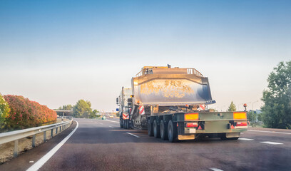 Oversize load truck transporting a huge excavator machine