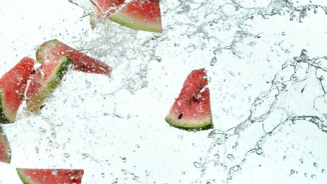 Super slow motion of water melon pieces flying up in the air with water splashes. Filmed on high speed cinema camera, 1000 fps.