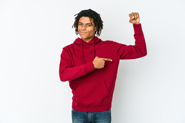 Young african american rasta man showing strength gesture with arms, symbol of feminine power