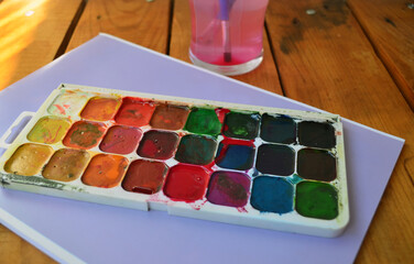Multicolored palette of watercolor paints with brushes. Art, drawing.