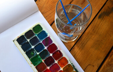 Multicolored palette of watercolor paints with brushes. Art, drawing.