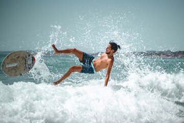 One skimboarder falling off the board when trying to catch a wave at Can Pere Antoni beach (Palma de Mallorca, Spain)