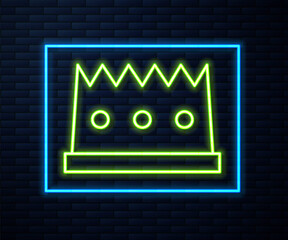 Glowing neon line King crown icon isolated on brick wall background. Vector.