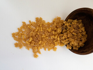 Pasta for children in a wooden bowl on a white background