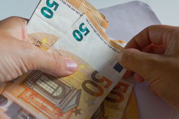 Businesswoman hands holding and counting 50 euro banknotes.