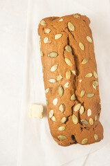 Fresh homemade pumpkin bread with pumpkin puree, cinnamon, nutmeg and seeds, isolated on white background, photographed overhead.