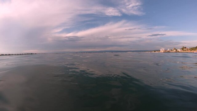 Calm waves and beautiful sky over Adriatic Sea. Low angle above the surface view. Slow motion, wide angle