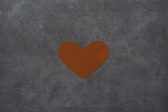 Heart shape of spreading cocoa powder onc oncrete background